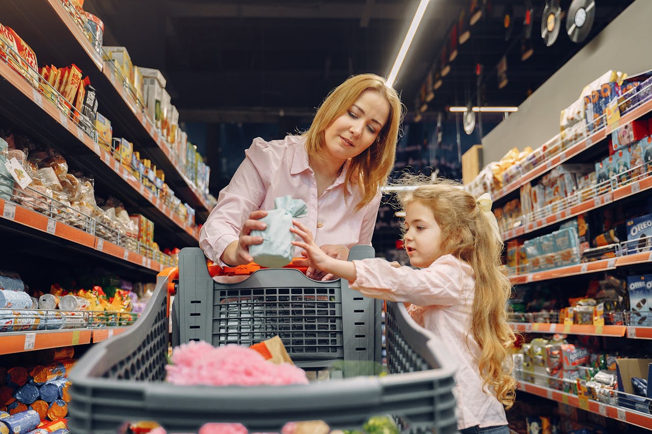 Home A mother and daughter shopping together in a supermarket aisle, enjoying quality time.