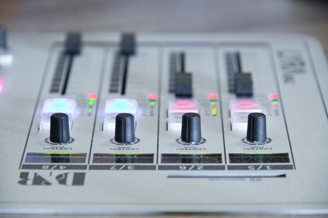 Detailed view of an audio mixer with knobs and control sliders for sound adjustment.