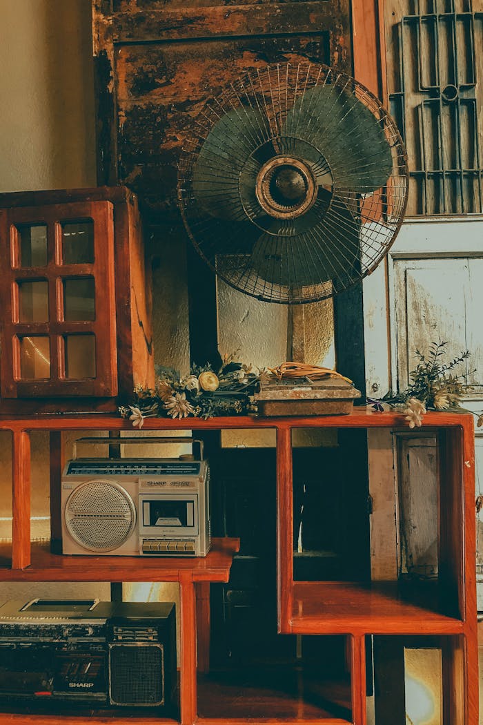 A nostalgic look into vintage Vietnamese living room decor featuring an old fan, radio, and wooden furniture.